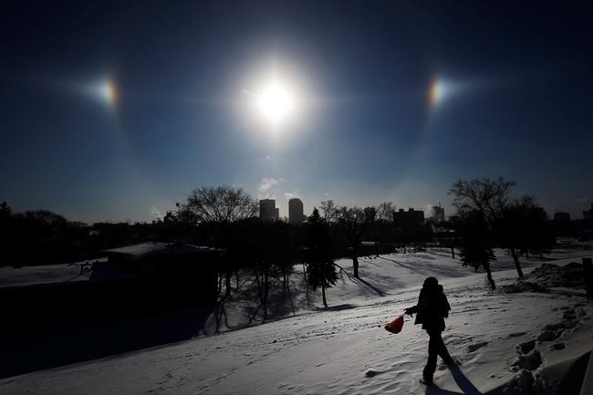 Sun Dogs, formed by the sun reflecting off ice crystals in bitterly cold temperatures, sit over the Winnipeg skyline Wednesday, Jan. 30, 2019. Winnipeg and the region has been experiencing below -35 degree celsius temperatures and windchills of -45 to -50 degree celsius. THE CANADIAN PRESS/John Woods