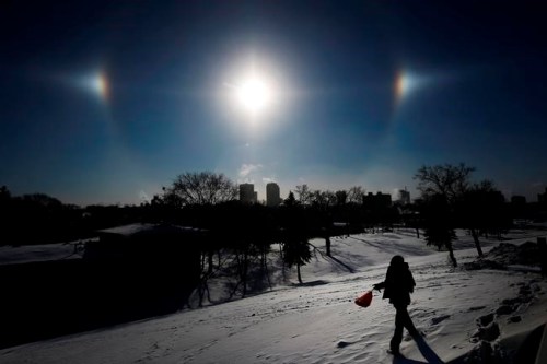 Sun Dogs, formed by the sun reflecting off ice crystals in bitterly cold temperatures, sit over the Winnipeg skyline Wednesday, Jan. 30, 2019. Winnipeg and the region has been experiencing below -35 degree celsius temperatures and windchills of -45 to -50 degree celsius. THE CANADIAN PRESS/John Woods