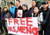 People hold a sign at a B.C. courthouse prior to the bail hearing for Meng Wanzhou, Huawei's chief financial officer on Monday, December 10, 2018. THE CANADIAN PRESS/Jonathan Hayward