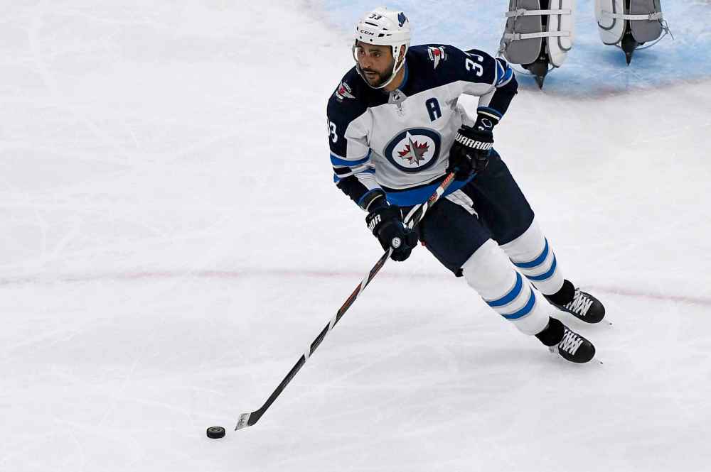Winnipeg Jets defenseman Dustin Byfuglien (33) moves the puck during the second period of an NHL hockey game against the Chicago Blackhawks. (AP Photo/Matt Marton)