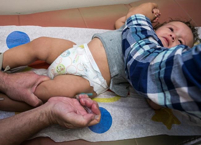 FILE - In this Jan. 29, 2015, file photo, pediatrician Charles Goodman vaccinates 1-year-old Cameron Fierro with the measles-mumps-rubella vaccine, or MMR vaccine, at his practice in Northridge, Calif. A new study published in the journal Science suggests the measles vaccine not only prevents measles, but may also help the body ward off other infections. State health officials say the number of measles cases is up in California this year and much of the increase is linked to overseas travel. Dr. Karen Smith, director of the California Department of Public Health, says the state recorded 38 measles cases as of Thursday, April 25, 2019, versus 11 around the same time last year. She says the state typically sees fewer than two dozen cases a year. (AP Photo/Damian Dovarganes,File)