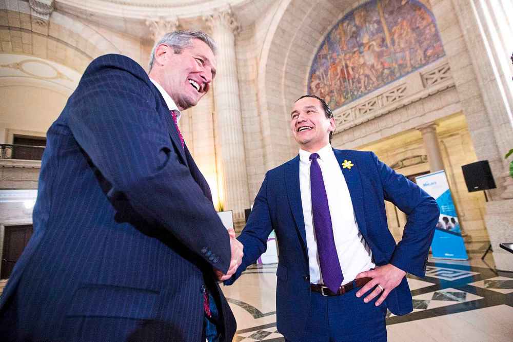 MIKAELA MACKENZIE / WINNIPEG FREE PRESS
Premier Brian Pallister, left, and opposition leader Wab Kinew shake hands during a scrum about a meeting between the two at the Manitoba Legislative Building in Winnipeg on Monday.