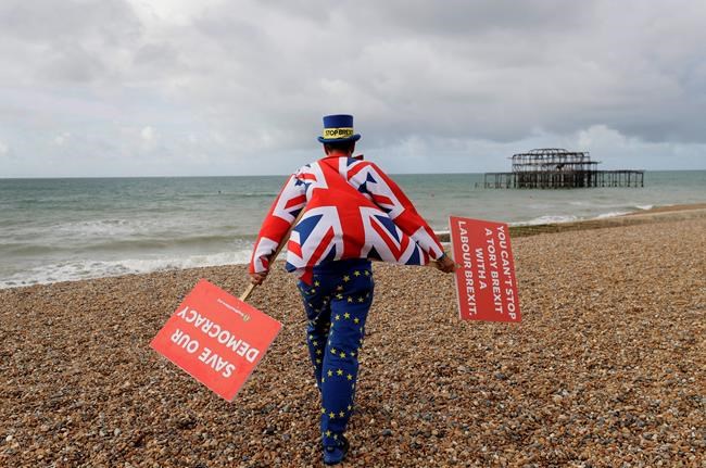 Anti Brexit campaigner Steve Bray walks on the beach to pose for a photograph during the Labour Party Conference at the Brighton Centre in Brighton, England, Monday, Sept. 23, 2019. (AP Photo/Kirsty Wigglesworth)