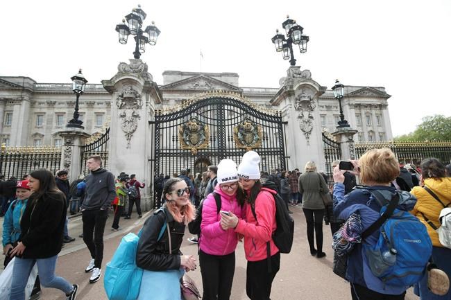 People gather outside Buckingham Palace in London on Monday after Prince Harry announced his wife Meghan had given birth to a baby boy. (Yui Mok / The Assocaited Press)