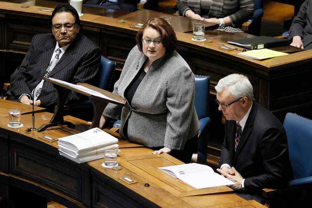 John Woods / The Canadian Press
Manitoba Finance Minister Jennifer Howard reads the provincial budget as minister Eric Robinson (left) and Premier Greg Selinger listen in at the Manitoba Legislature.