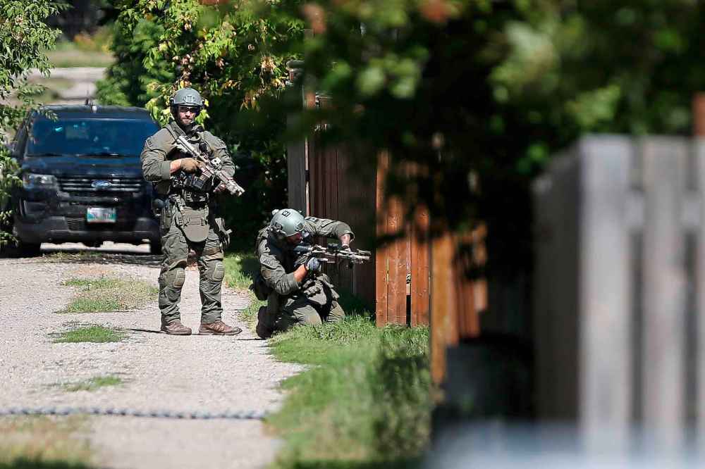 John Woods / The Canadian Press
The RCMP emergency response unit moves in on a home in Neepawa.