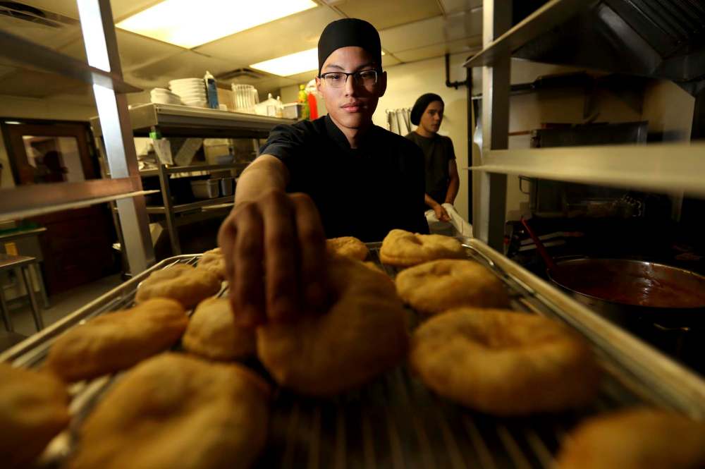 TREVOR HAGAN / WINNIPEG FREE PRESS
Braydon Kirkness grabs one of the bannock buns served with a few Feast specialties.