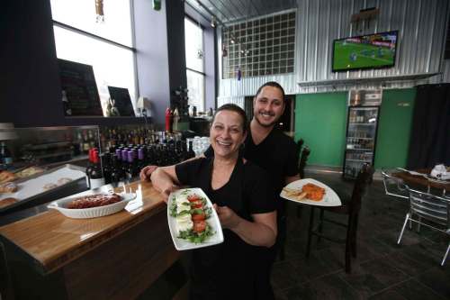 RUTH BONNEVILLE / WINNIPEG FREE PRESS
Chef Carla Canfriglia and her son, Giuliano Ghersevich, with (from left) lasagna alla Bolognese, caprese salad and pollo alla Forestiera.