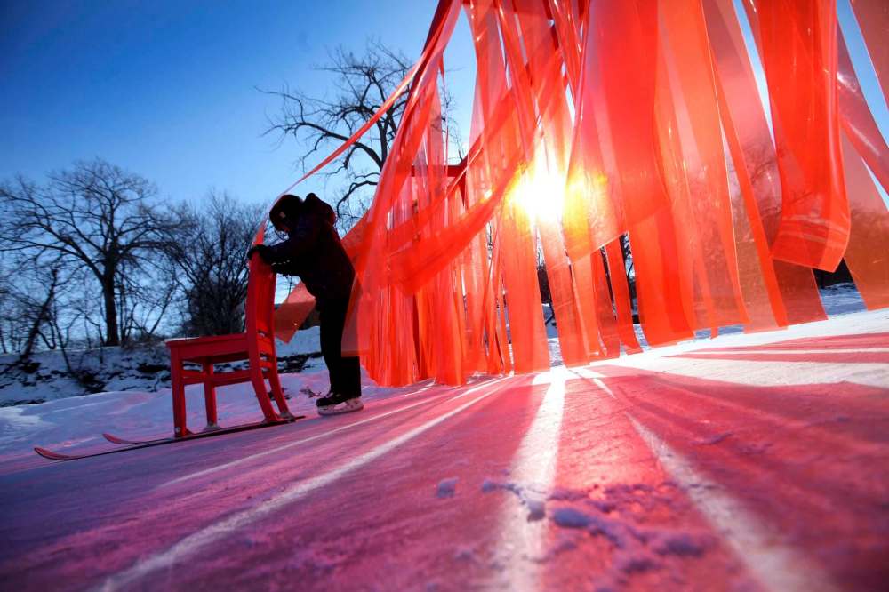 RUTH BONNEVILLE / WINNIPEG FREE PRESS
Ethan Offman, age 9, pushes a kicksled through the Open Border warming hut, a wall made out of orange plastic strips hanging across the river trail along the Assiniboine River.
