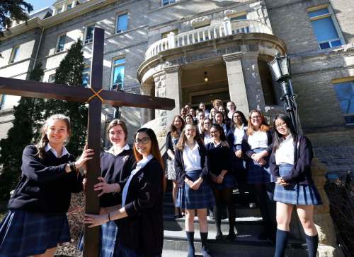 Students Deirdre Beaumont (left to right), Marysa Fosty and Alliah Ramirez hold the cross to be used on Good Friday in front of St. Mary&rsquo;s Academy. (Wayne Glowacki / Winnipeg Free Press)
