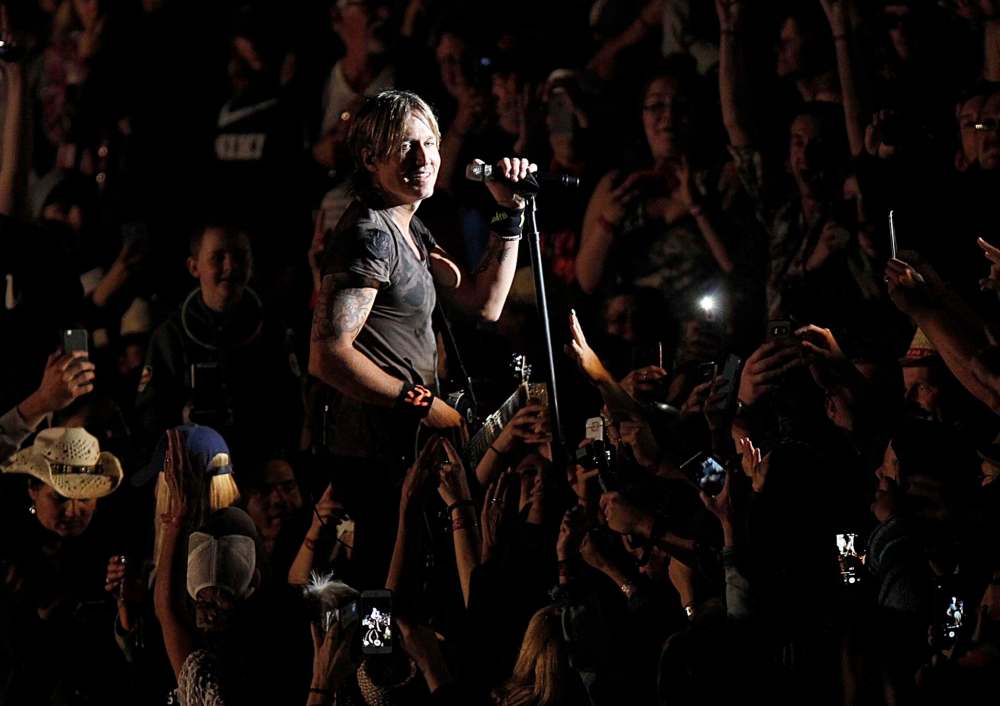 PHIL HOSSACK / WINNIPEG FREE PRESS
Keith Urban delights fans in the cheap seats as he performs in the centre of the crowd Friday night at Dauphin's Countryfest.