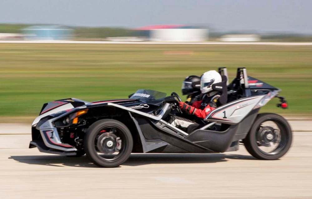 The three-wheeled Polaris Slingshot features two wheels up front and one in the rear, a tilt steering wheel and side-by-side bucket seats equipped with seatbelts.