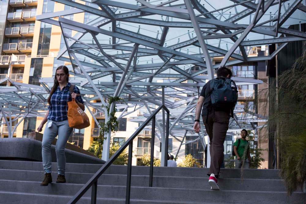 David Ryder / Washington Post.
People walk next to the Day 1 building at Amazon headquarters in Seattle.