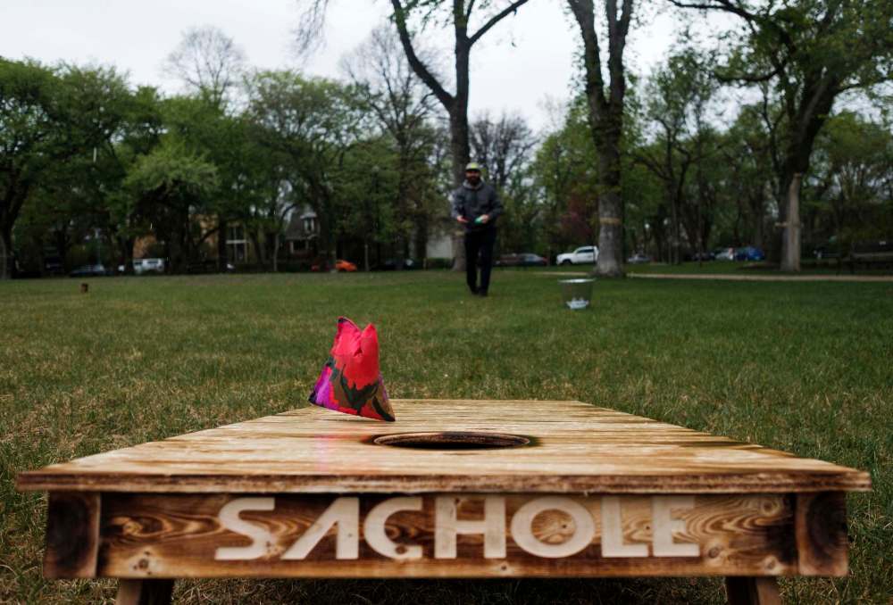 Daniel Crump / Winnipeg Free Press
Ashley Nichol demonstrates Sachole, a game where opponents take turns throwing beanbags into a hole on a board.