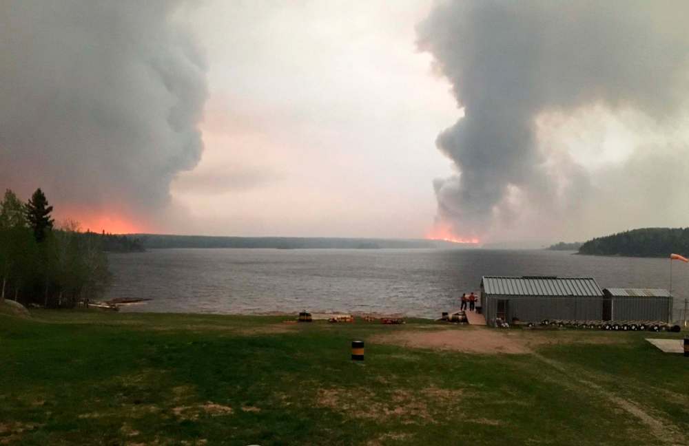 Government of Manitoba
Fires burn in Little Grand Rapids, Man., as shown in a Government of Manitoba handout photo.Hundreds of people from a Manitoba First Nation are sitting in the local school as a raging forest fire encroaches on the community. Evacuations from Little Grand Rapids - a fly-in community about 260 kilometres northeast of Winnipeg - began on Tuesday but heavy smoke made it impossible for planes to land.