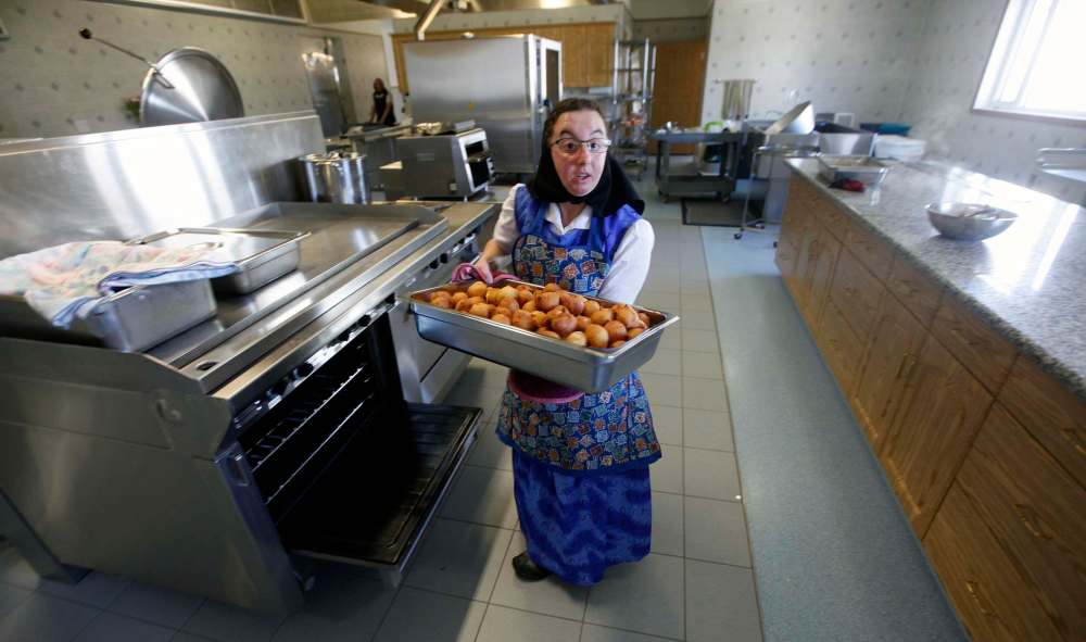 PHIL HOSSACK/Winnipeg Free Press
Melissa Hofer removes cooked dumplings from an oven the James Valley Hutterite Colony.