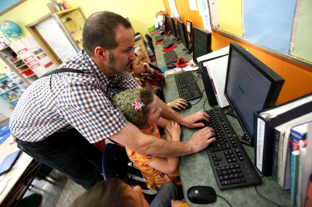 PHIL HOSSACK / WINNIPEG FREE PRESS
Crystal Springs school teacher and historian Ian Kleinsasser helps his elementary school students work in his computer-equipped classroom in Crystal Springs.