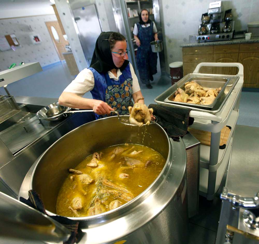 PHIL HOSSACK/Winnipeg Free Press
Melissa Hofer removes cooked chicken from a huge soup pot at the James Valley Hutterite Colony community kitchen.