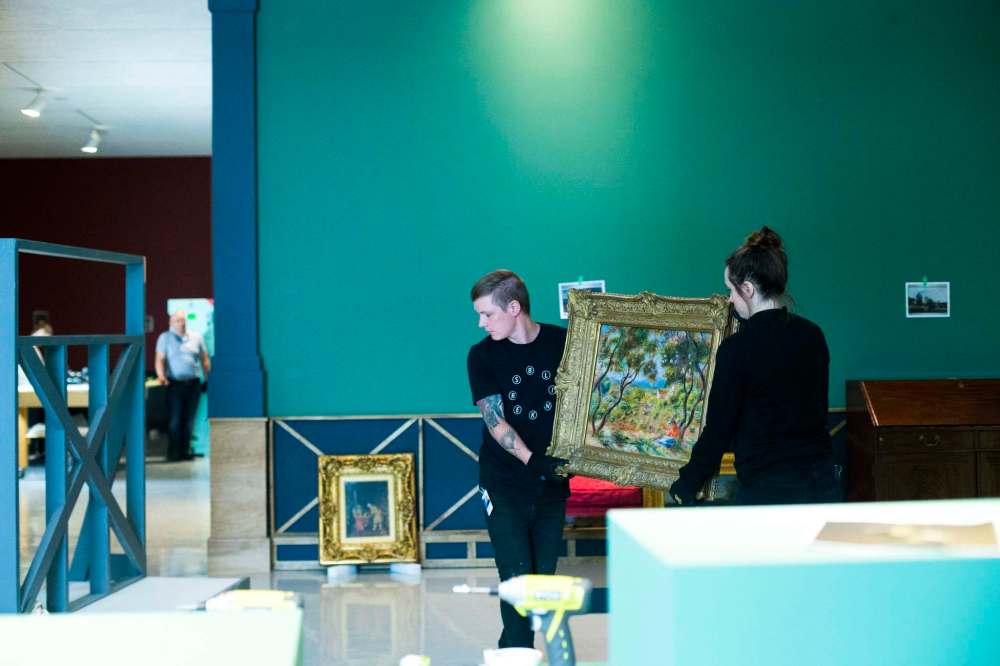 Preparators Serge Saurette (left) and Kristina Banera uncrate paintings.