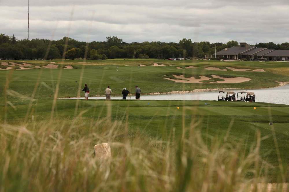 Tall grass surrounds the edge of the green as a group of members golf at the Southwood Golf & Country Club Wednesday. (Ruth Bonneville / Winnipeg Free Press)