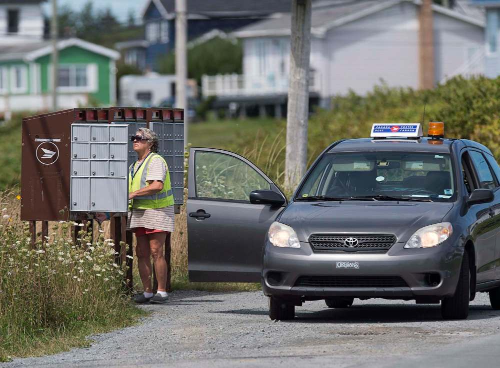 Andrew Vaughan / The Canadain Press Files
A Canada Post rural and suburban mail courier tends to a community mailbox. Canada Post is having a nationwide rollout of a program to standardize the current address system, getting rid of rural route addresses in favour of civic addresses used by most of the country.