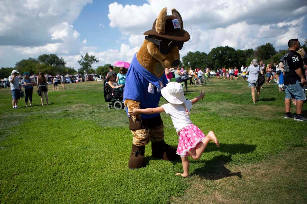 Making a connection: Willow Braun, 4, runs to hug the Folklorama Llama, portrayed by Free Press columnist Jen Zoratti.