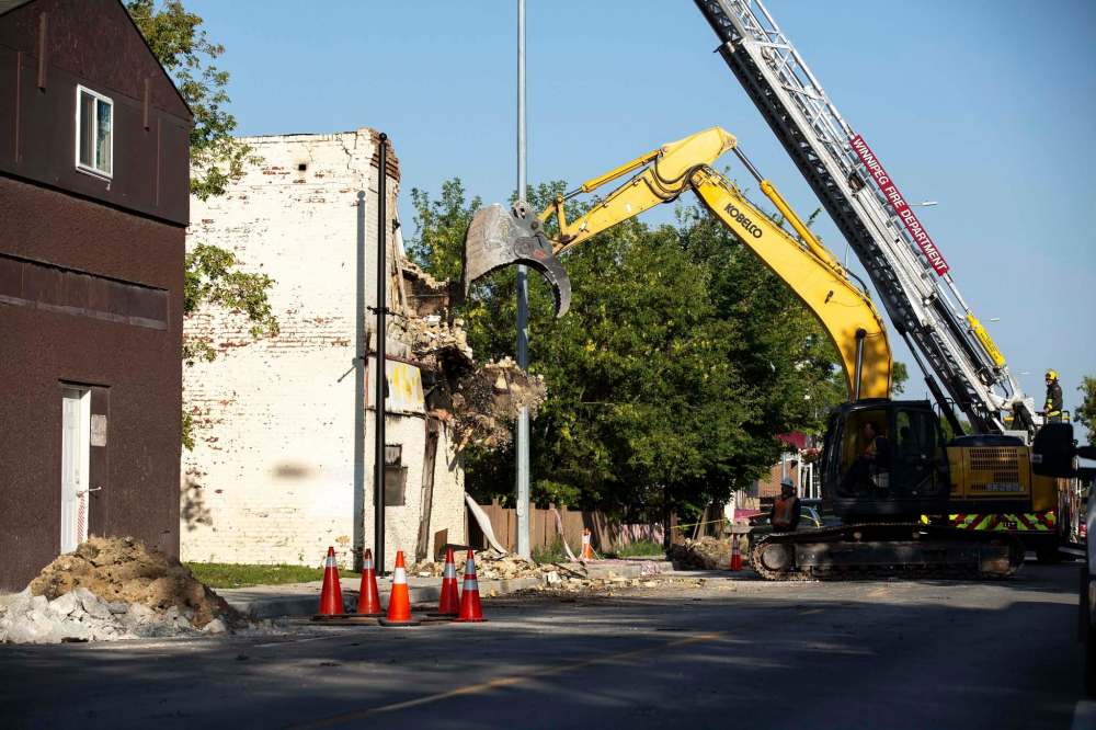 A demolition crew tears down the rooming house that caught fire overnight on Selkirk Avenue. (Andrew Ryan / Winnipeg Free Press)