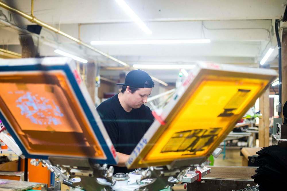 MIKAELA MACKENZIE / WINNIPEG FREE PRESS
Riley Taylor works on printing tote bags at the Floodway Print Co. in their new space in the exchange district in Winnipeg on Thursday, Aug. 16, 2018.
Winnipeg Free Press 2018.
