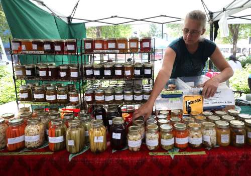RUTH BONNEVILLE / WINNIPEG FREE PRESS
Trudy Penner adjusts jams on her shelves at her vendors booth at the downtown farmers&rsquo; market at Hydro Place.