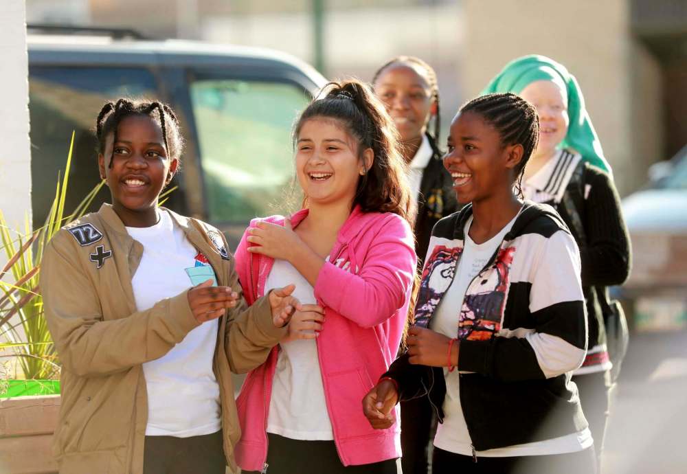 RUTH BONNEVILLE / WINNIPEG FREE PRESS
Plamedie Gatoro, left, Gabrielle Gonzalez and Christina Dusabimana celebrate the first day of their new school along with other students and teachers during ribbon cutting ceremony Wednesday.