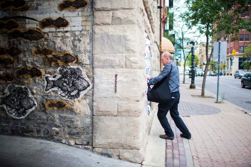 MIKAELA MACKENZIE / WINNIPEG FREE PRESS
Antero Lindblad puts up posters in the Exchange District.
