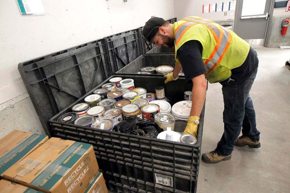 PHIL HOSSACK / WINNIPEG FREE PRESS - A city worker packs partially full paint containers into a crate at the city's newest 4R Recycling Depot on Panet Road Thursday. See Jill Wilson's story. - August 15, 2018