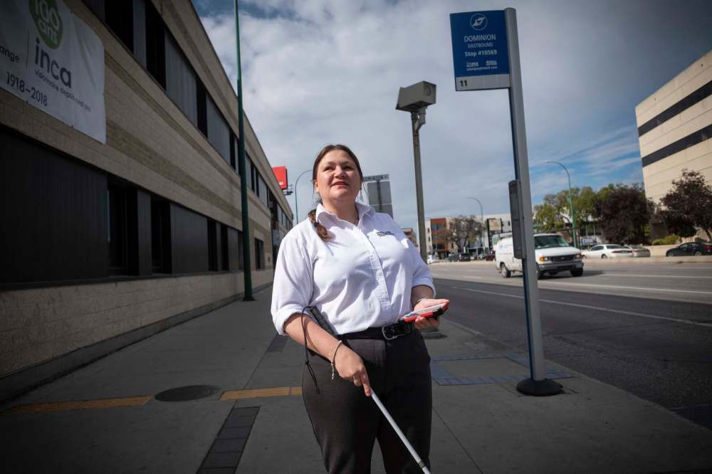 Brianna Fuellbrandt demonstrates the Key2Access app, which allows users to request a pedestrian crossing at traffic lights from their cellphone. Portage Avenue and Dominion Street is one of only two intersections currently set up for users with the app. (Daniel Crump / Winnipeg Free Press)
