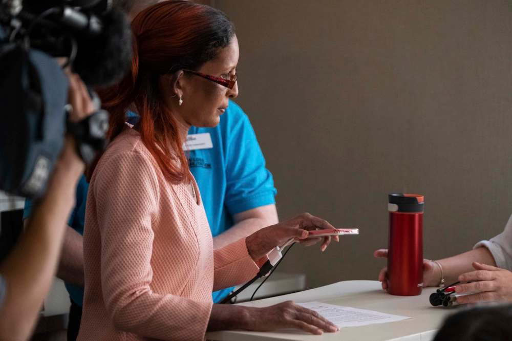 Vivi Dabee tries out the Seeing AI app, which harnesses the power of artificial intelligence to narrate the surrounding world by describing people, text and objects. (Daniel Crump / Winnipeg Free Press)