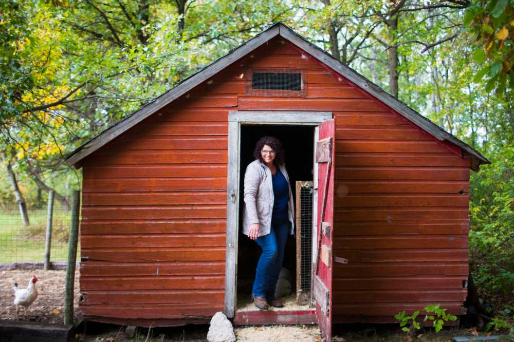 Tracy Wood comes out of the chicken coop at Farm Away.
