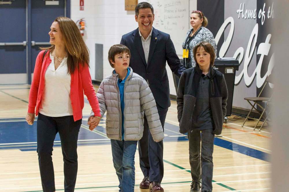 Brian and Tracy Bowman bring their kids Hayden, right, and Austin to the voting booth at École Charleswood School Wednesday morning. (Mike Deal / Winnipeg Free Press)