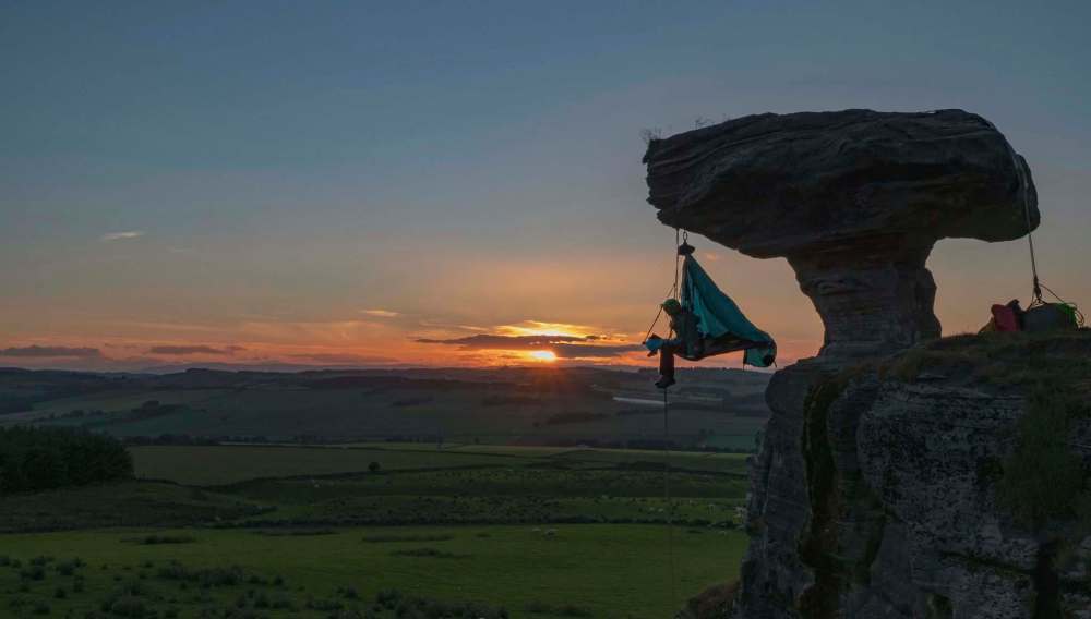 ‘Extreme sleeper‘ Phoebe Smith prepares for bed while hanging off Bunnet Stane (bonnet stone) in Fife, Scotland. (Zac Bentley photo)