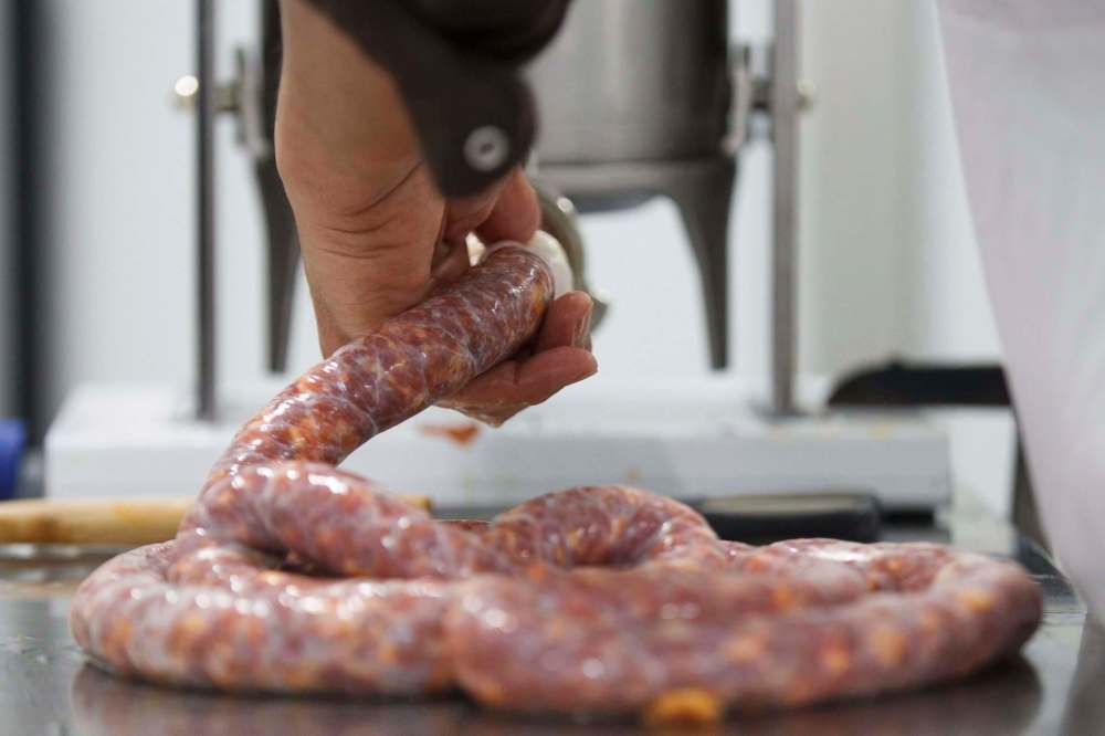 Sale directs the flow of meat into the casings for the chavacano sausages.