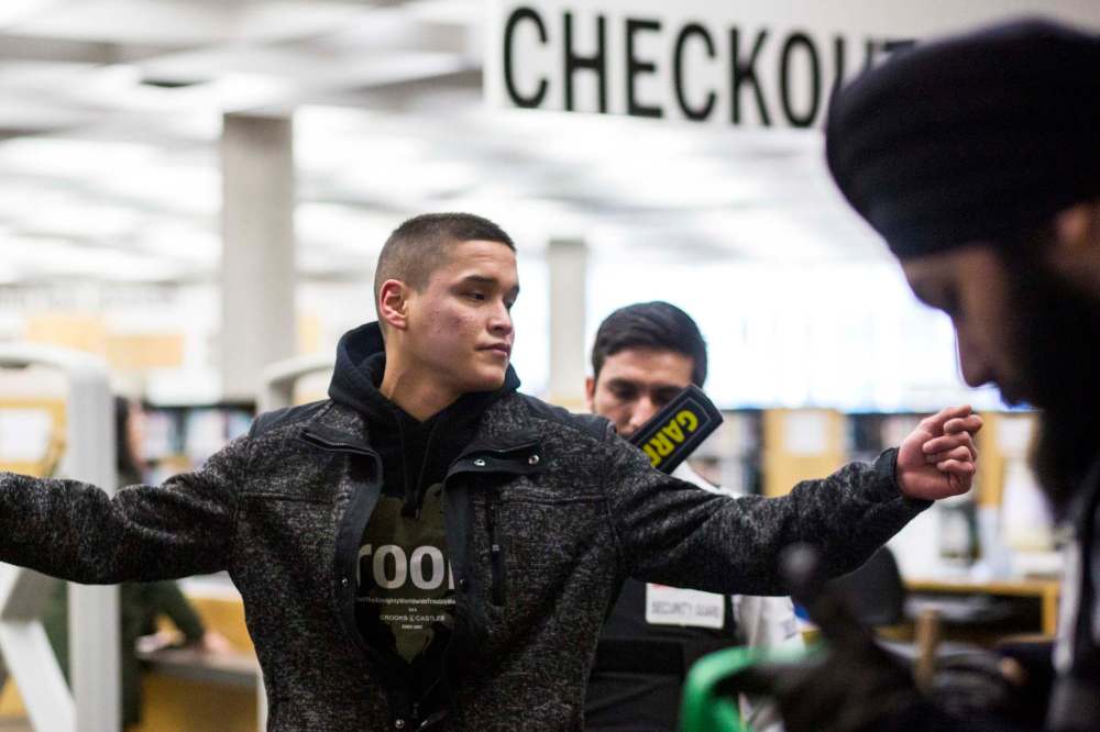 Joseph McKay gets scanned as new security measures come into effect at the Millennium Library on Monday. (Mikaela Mackenzie / Winnipeg Free Press)