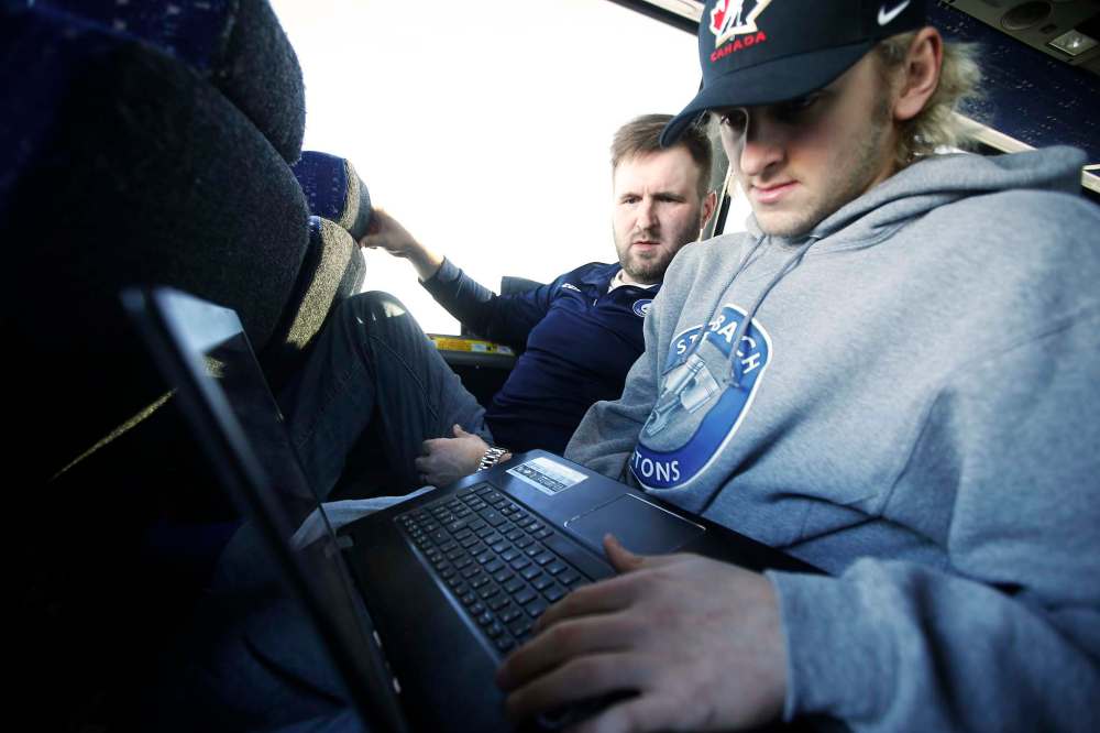 JOHN WOODS / WINNIPEG FREE PRESS
Steinbach Pistons assistant coach Calvin Bugyik (left) and forward Troy Beauchemin go over game film during the bus ride to Waywayseecappo.