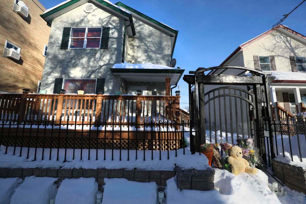 Flowers and a teddy bear at the gate of 745 McGee St., where 17-year-old Jaime Adao was slain during a home invasion Sunday night. (Ruth Bonneville / Free Press files)