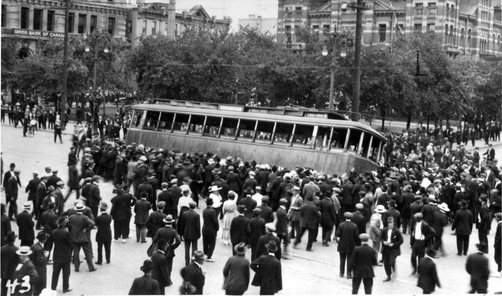 In one of the most iconic images from the strike, a streetcar is overturned on Main Street in front of the old city hall building. (Winnipeg Free Press files)