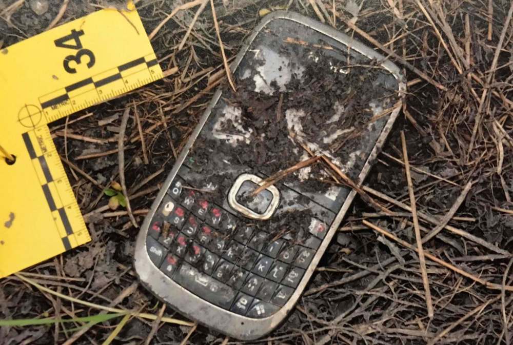 A photo in evidence at Brett Overby's trial shows Christine Wood's mobile phone discovered in the area her body was found.