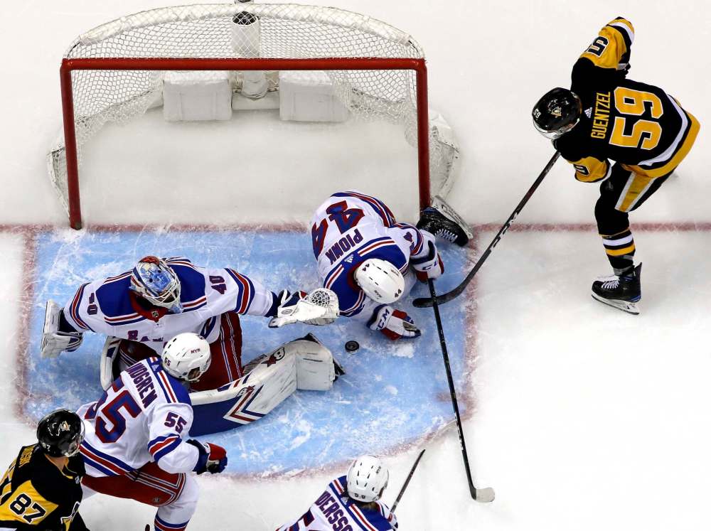 Gene J. Puskar / The Associated Press
Pittsburgh Penguins' Jake Guentzel (59) gets to a rebound off New York Rangers goaltender Alexandar Georgiev a beats Neal Pionk (44) during a game against the New York Rangers in Pittsburgh in April.