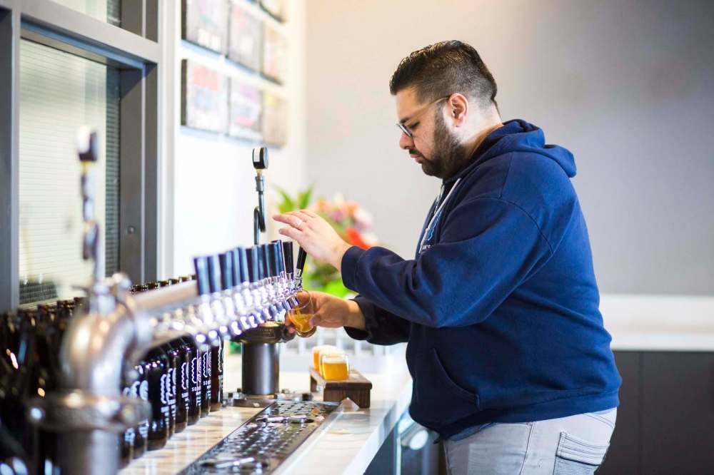 MIKAELA MACKENZIE / WINNIPEG FREE PRESS files
Andrew Sookram of Sookram's Brewing Co. pours flights of beer in his Warsaw Ave. tap room. A recent addition to Winnipeg beer tasting tours, he says feedback from the public has so far been overwhelmingly positive.