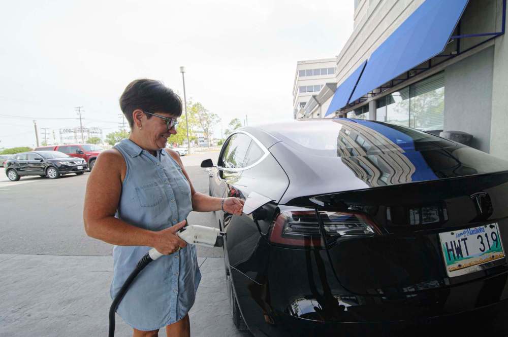MIKE SUDOMA / WINNIPEG FREE PRESS
Ruth Deane recharging her Tesla Model 3 at a electric recharge station at the Hilton hotel.