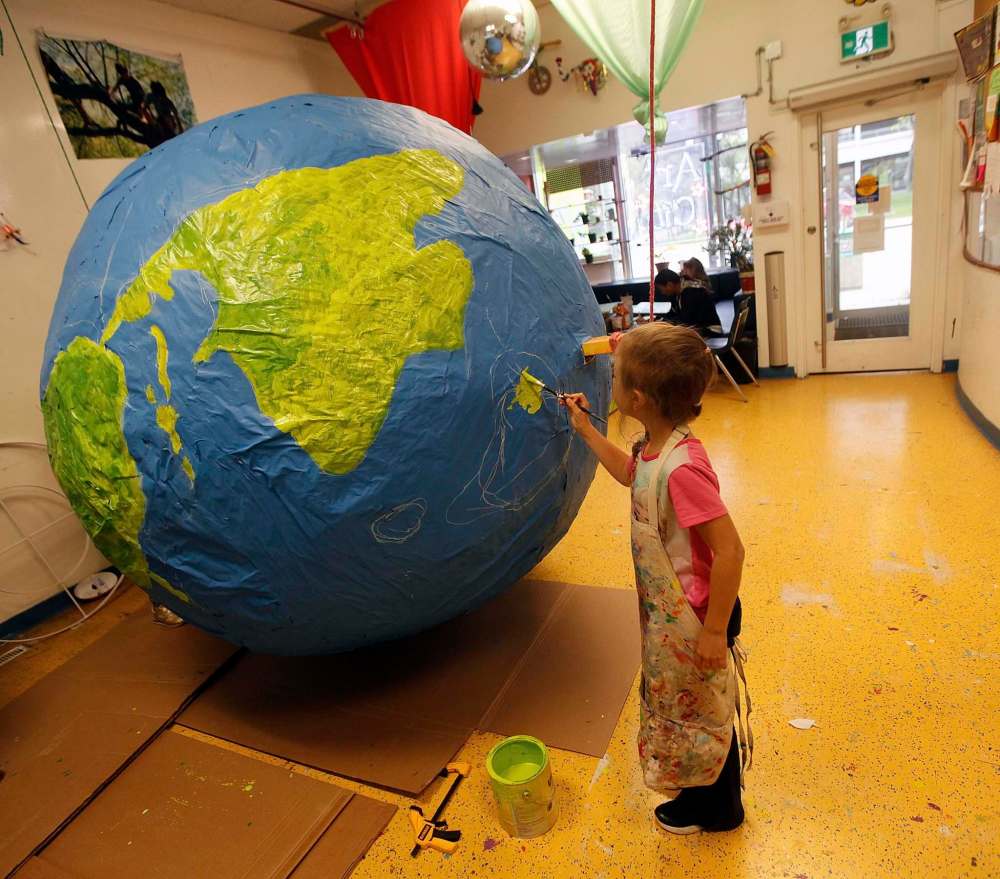 Emma Loshakova, 8, works Tuesday afternoon on the giant paper mâché globe. (Phil Hossack / Winnipeg Free Press)