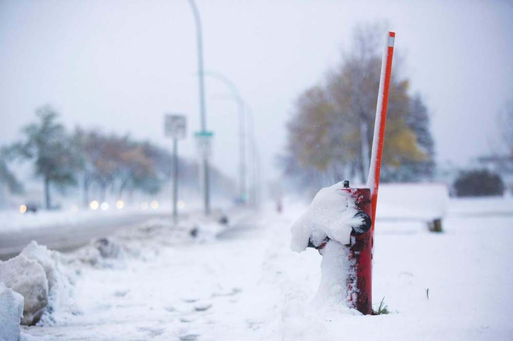 A fire hydrant on Inkster Boulevard at Sheppard Street is covered in snow. (Mikaela MacKenzie / Winnipeg Free Press)