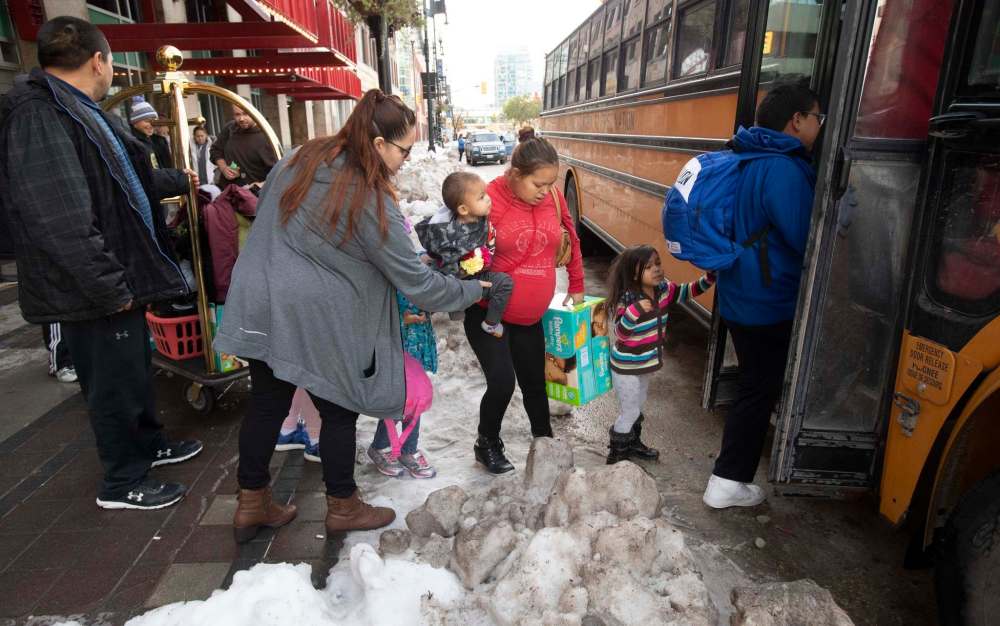 Evacuated families from the Lake Manitoba First Nation load their belongings onto a bus outside a hotel in Winnipeg on Monday. (Adrian Wyld / The Canadian Press)