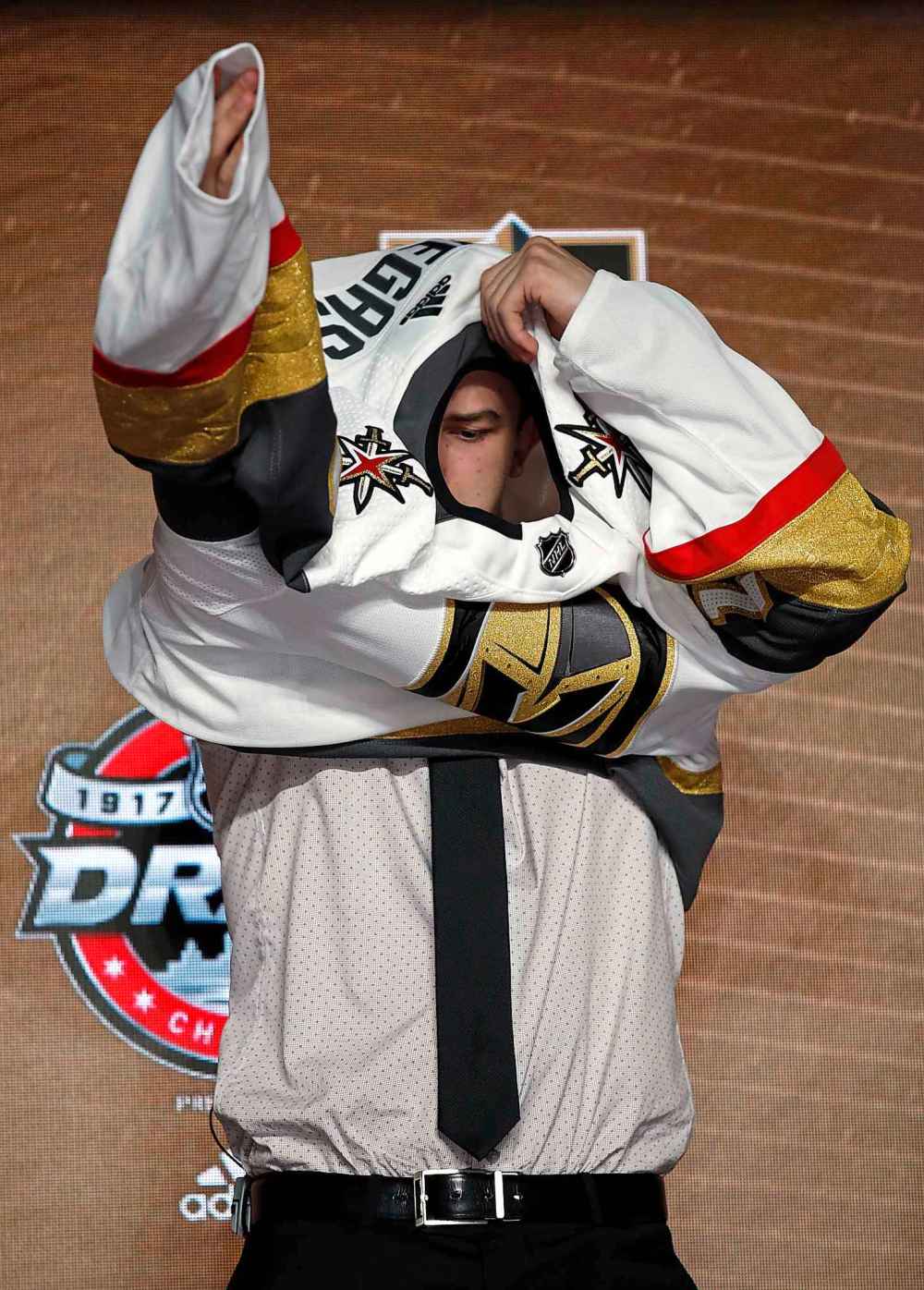CP
Cody Glass puts on a Vegas Golden Knights jersey after being selected by the team in the first round of the NHL hockey draft, Friday, June 23, 2017, in Chicago. (AP Photo/Nam Y. Huh)